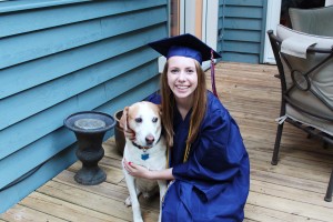 Girl in a graduation gown with her dog