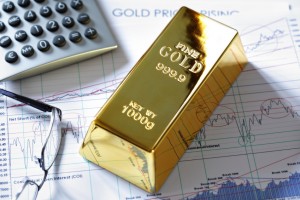 Gold ingot resting on a stocks and shares graph representing investment or banking